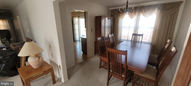 dining room with a chandelier and light carpet