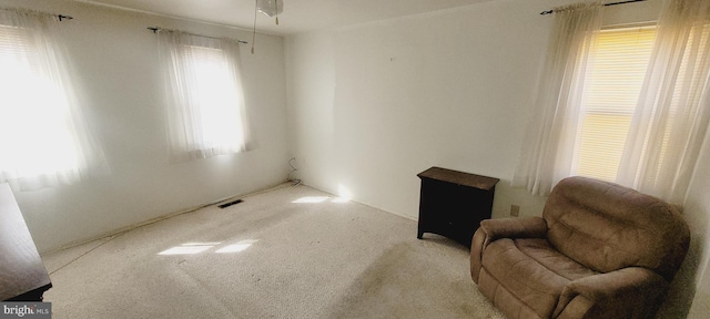 living area featuring visible vents and carpet flooring