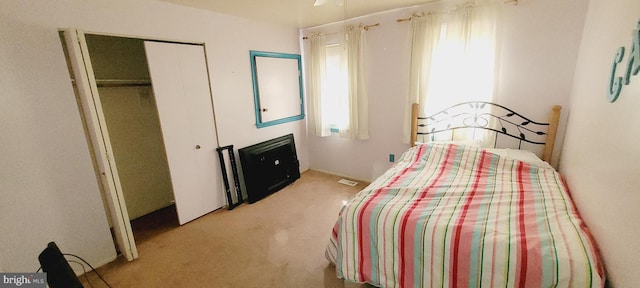 bedroom featuring light colored carpet and multiple windows