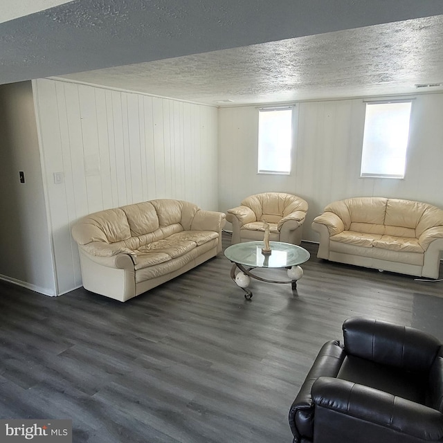 living area featuring a textured ceiling, wood finished floors, and visible vents