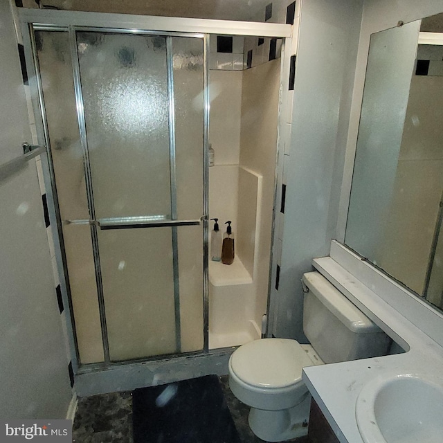 bathroom featuring a stall shower, vanity, and toilet