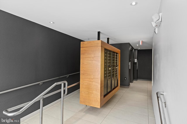 corridor featuring a mail area and light tile patterned floors