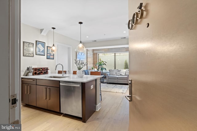 kitchen with pendant lighting, sink, dark brown cabinetry, light hardwood / wood-style floors, and stainless steel dishwasher