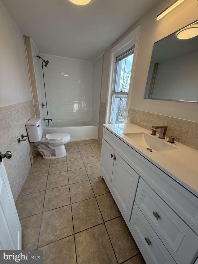 full bathroom featuring tile patterned floors, toilet, tile walls, vanity, and tiled shower / bath combo