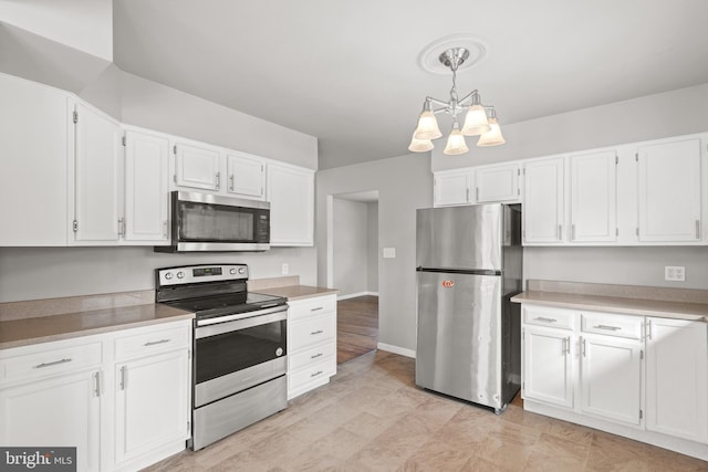 kitchen with decorative light fixtures, light countertops, appliances with stainless steel finishes, a notable chandelier, and white cabinets