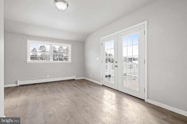 empty room with wood finished floors, french doors, baseboards, and a baseboard radiator