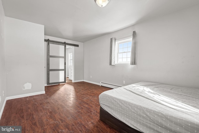 bedroom featuring a barn door, wood finished floors, baseboards, and a baseboard heating unit