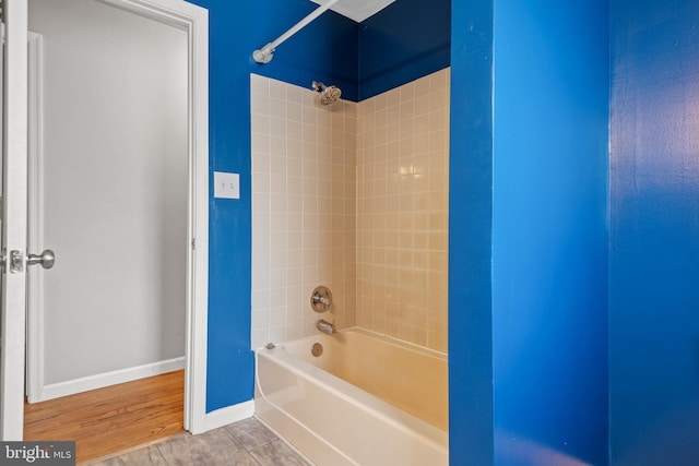 full bath featuring baseboards and  shower combination