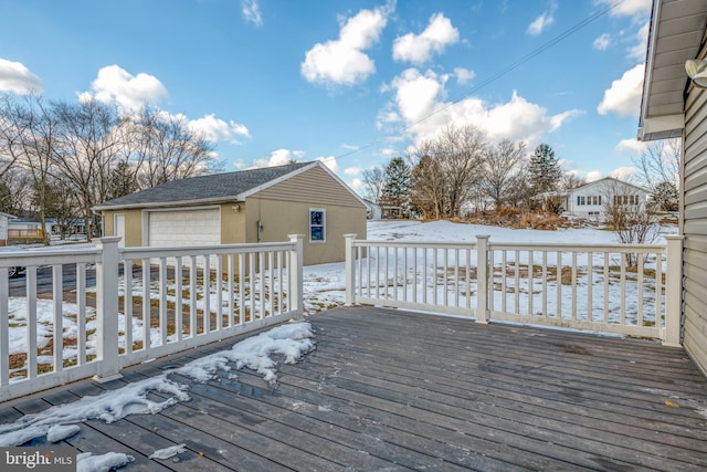 snow covered deck with an outdoor structure and a detached garage