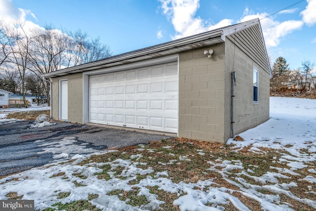 snow covered garage with a garage