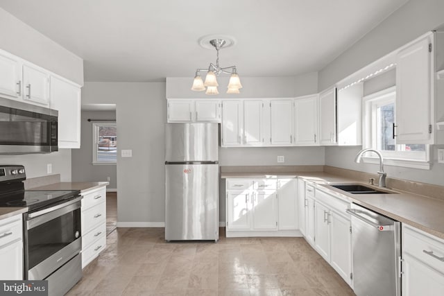 kitchen with white cabinets, appliances with stainless steel finishes, and a sink