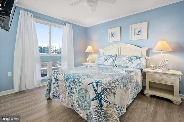 bedroom featuring hardwood / wood-style flooring, ornamental molding, and ceiling fan