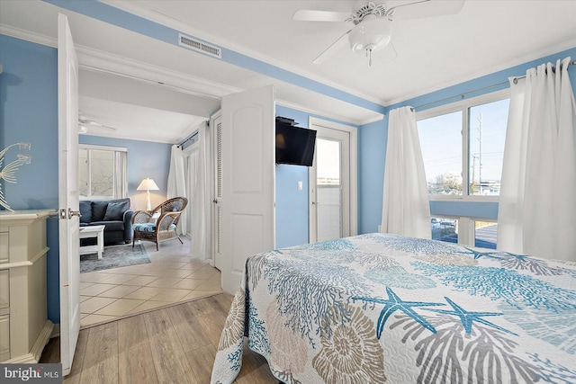 bedroom with ornamental molding, ceiling fan, and light hardwood / wood-style floors