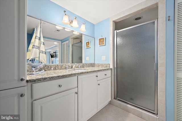 bathroom with vanity, a shower with door, and tile patterned floors