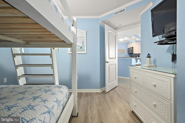 bedroom featuring ornamental molding and light wood-type flooring