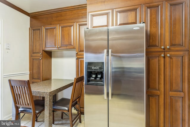 kitchen with ornamental molding and stainless steel fridge