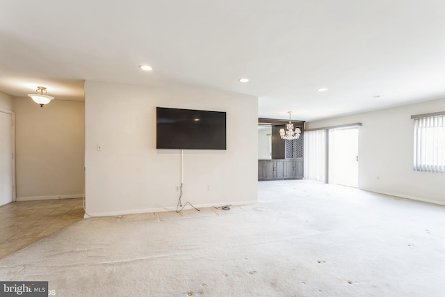 unfurnished living room with light carpet and a chandelier