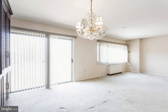 carpeted spare room with a chandelier