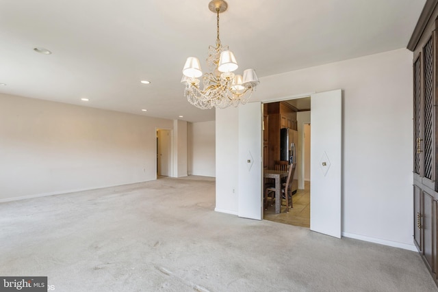 carpeted spare room featuring a notable chandelier