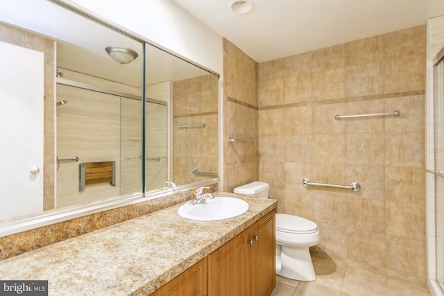 bathroom with tile walls, vanity, walk in shower, toilet, and tile patterned floors