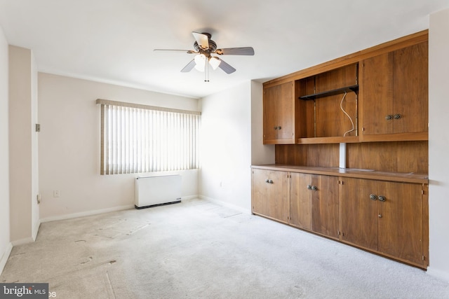 unfurnished living room featuring ceiling fan and light colored carpet