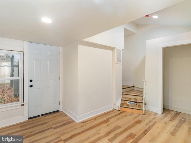 foyer entrance with lofted ceiling and light wood-type flooring