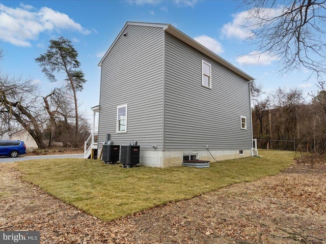 view of home's exterior featuring central AC unit and a lawn