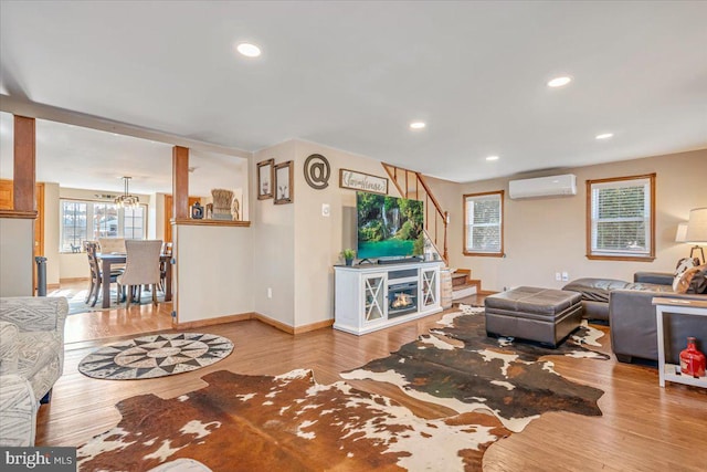 living room featuring a wall mounted AC and light wood-type flooring