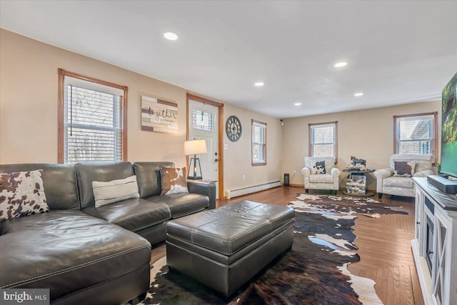 living room featuring baseboard heating and hardwood / wood-style floors