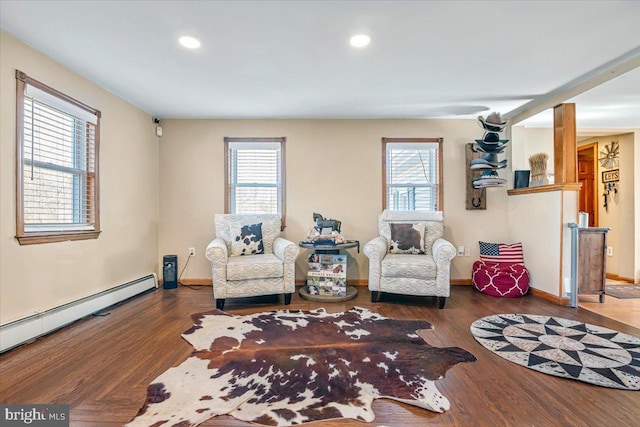 living area featuring baseboard heating, hardwood / wood-style floors, and a wealth of natural light