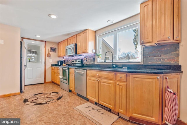 kitchen with sink, backsplash, and appliances with stainless steel finishes