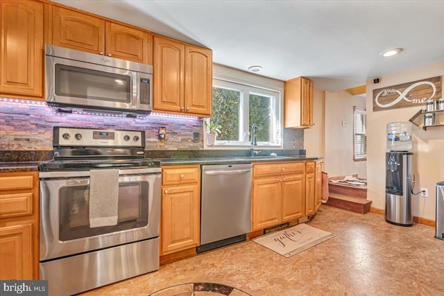 kitchen featuring stainless steel appliances, sink, and backsplash