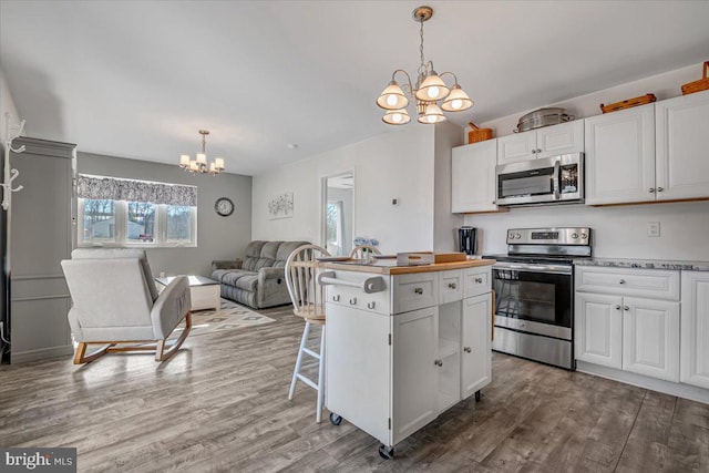 kitchen featuring white cabinetry, a notable chandelier, and stainless steel appliances