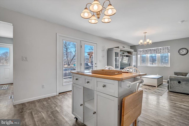 kitchen with white cabinetry, a center island, a chandelier, and light hardwood / wood-style flooring