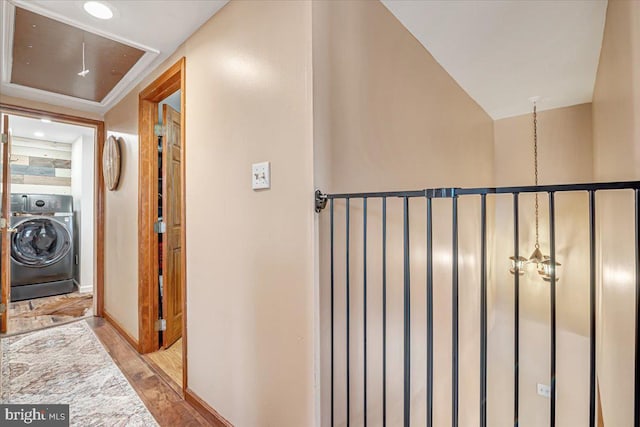 corridor with washer / dryer and light wood-type flooring