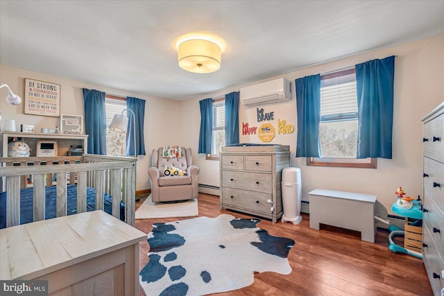 bedroom featuring multiple windows, hardwood / wood-style flooring, and a wall mounted AC