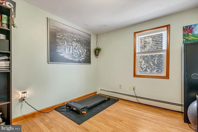 workout area with a baseboard heating unit and hardwood / wood-style floors