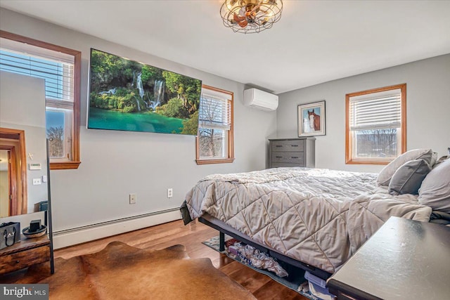 bedroom with hardwood / wood-style flooring, a wall unit AC, and baseboard heating