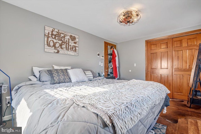 bedroom with dark wood-type flooring and a closet