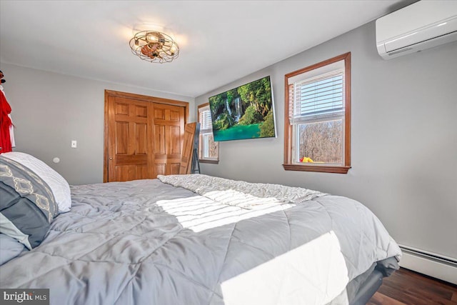 bedroom with dark hardwood / wood-style floors, a baseboard radiator, a closet, and a wall mounted AC