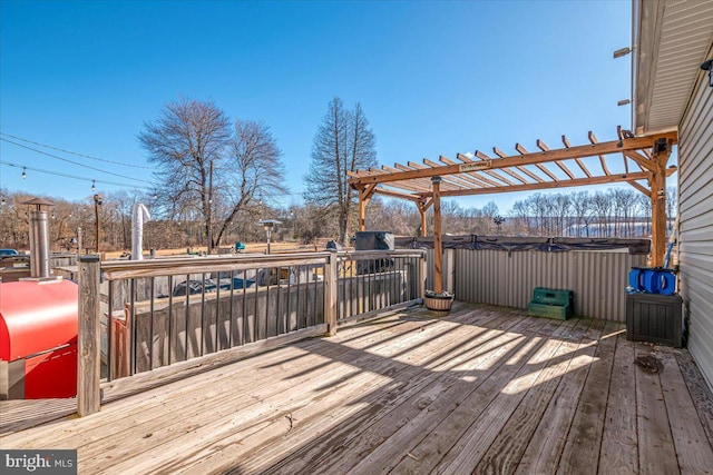 deck with a hot tub and a pergola