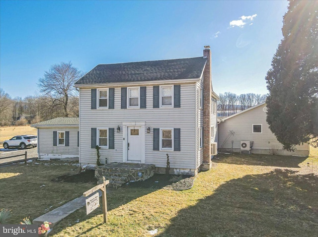 colonial-style house featuring a front lawn