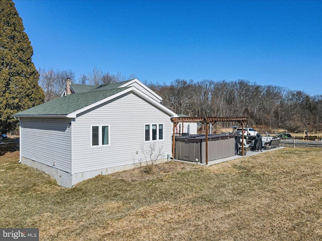 view of property exterior with a yard, a hot tub, a pergola, and a patio