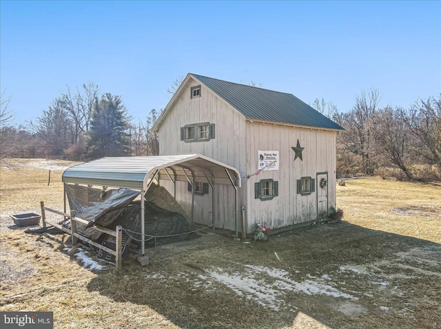 view of outdoor structure with a carport and a lawn