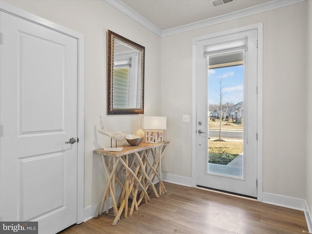 doorway to outside with crown molding and light hardwood / wood-style floors