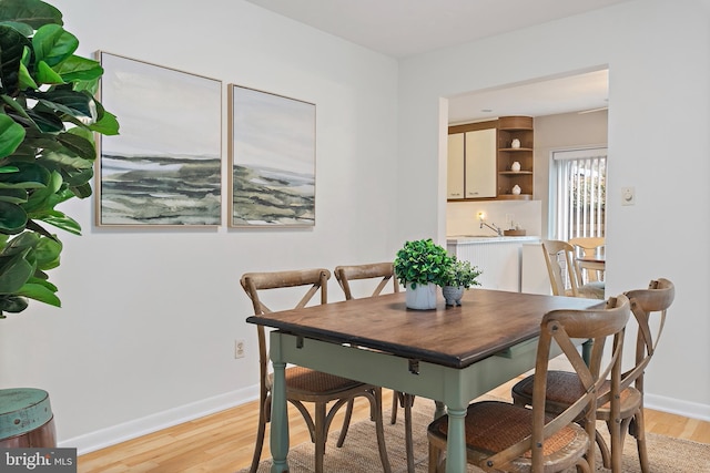 dining room featuring light wood-style floors and baseboards