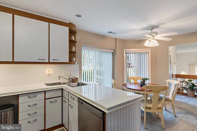 kitchen featuring visible vents, light countertops, a sink, dishwasher, and a peninsula