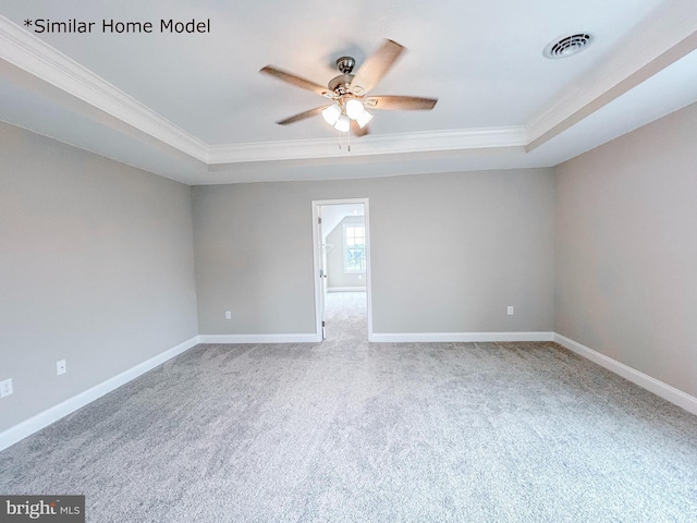 carpeted empty room featuring crown molding, a raised ceiling, and ceiling fan