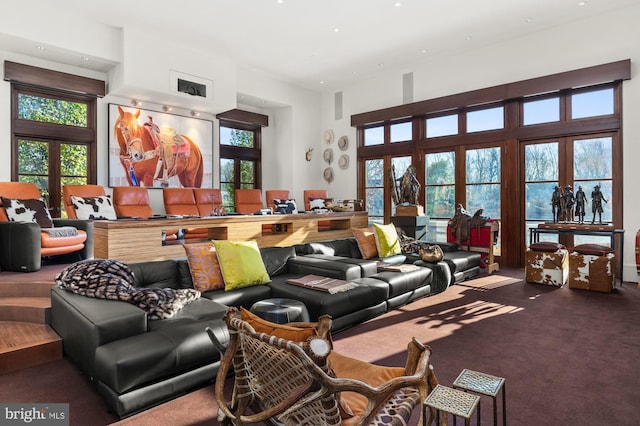 living room featuring a towering ceiling, french doors, and carpet flooring