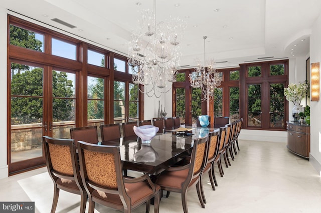 dining room with a raised ceiling and a notable chandelier